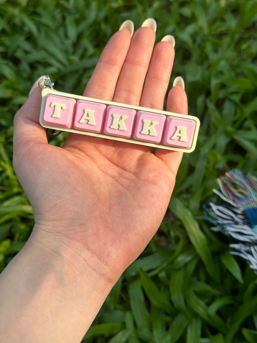 Personalized TAKKA keyboard key toy keychain shown in hand for scale