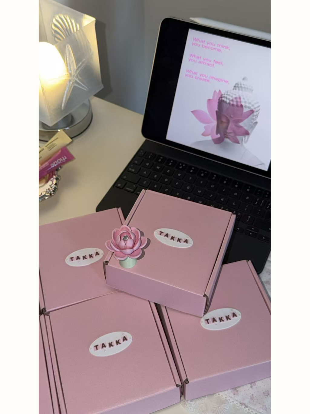 Takka lotus charm displayed on pink packaging
